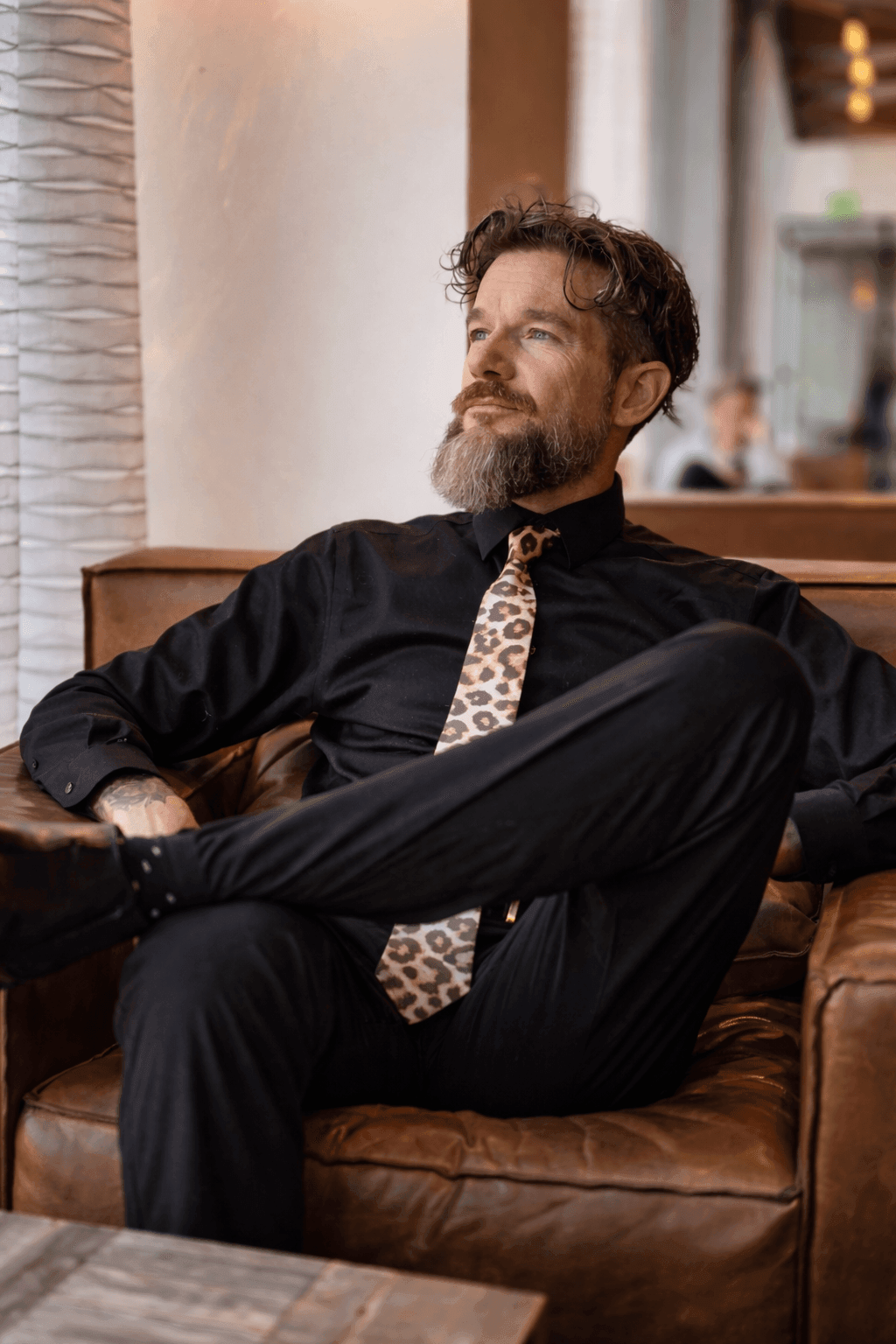 Sir Christopher relationship and power dynamics coach sitting thoughtfully in a chair looking toward natural light. Sir Christopher relationship and power dynamics coach sitting thoughtfully in a chair looking toward natural light.