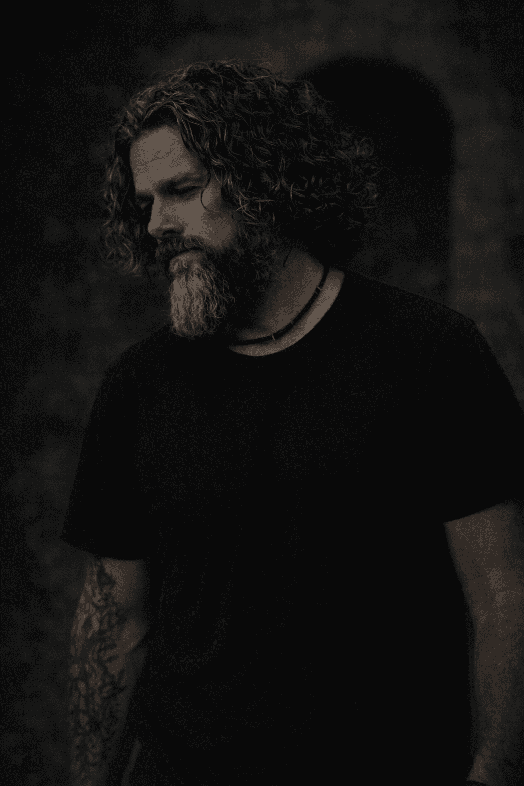 Portrait of Sir Christopher in a dark shirt, looking thoughtful in soft, moody light Portrait of Sir Christopher in a dark shirt, looking thoughtful in soft, moody light